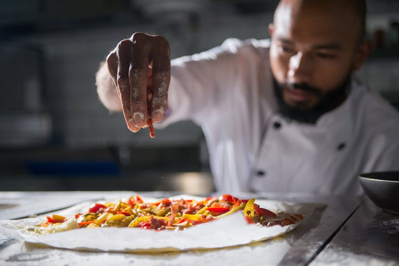 Fresh deep-dish pizza being prepared at Jet's Pizza kitchen